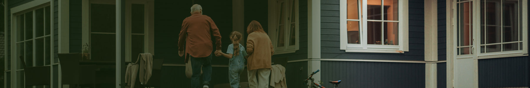 Family entering a cozy single-family home with inviting porch and large windows, ideal for comfortable living.
